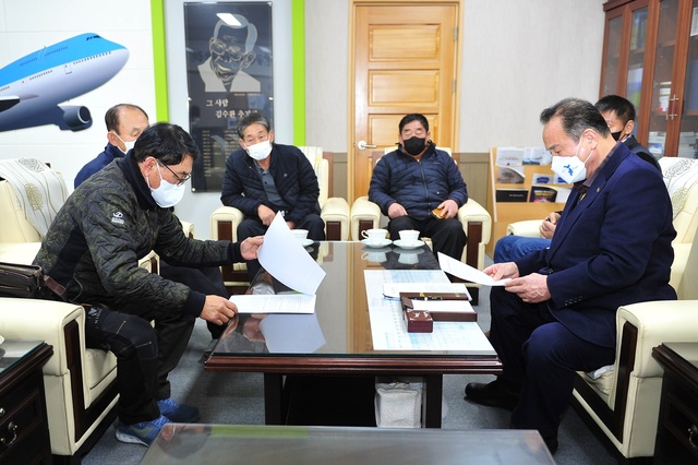 ▲ 군위군 통합신공항추진위원회(회장:박한배)는 10일 저녁 군위군청을 항의방문하고 김영만 군위군수(오른쪽)에게 항의 성명서를 전달했다.ⓒ군위군