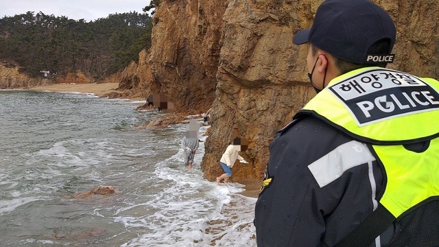 ▲ 태안해양경찰서 해경이 19일 오후 4시 15분쯤 태안군 소원면 해식동굴 갯바위에 고립됐던 관광객 14명을 전원 구조하고 안전지대로 이동시키고 있다.ⓒ태안해양경찰서