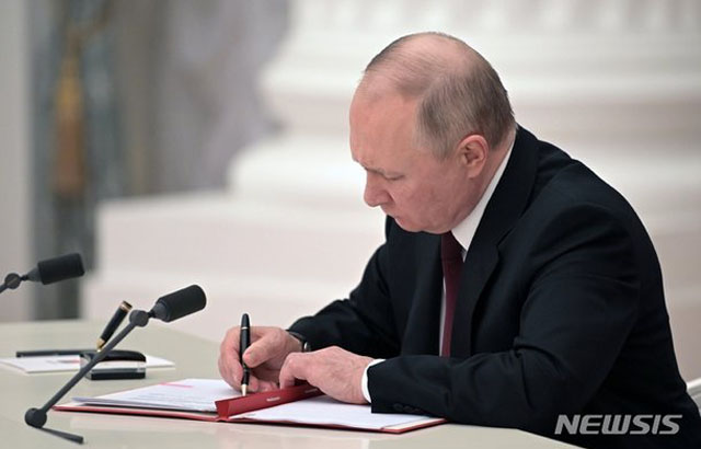 21일(현지시간) 블라디미르 푸틴 러시아 대통령이 돈바스 지역을 점유한 분리주의 반군세력을 정식국가로 승인한다는 행정명령에 서명하고 있다. ⓒ뉴시스 AP. 무단전재 및 재배포 금지.