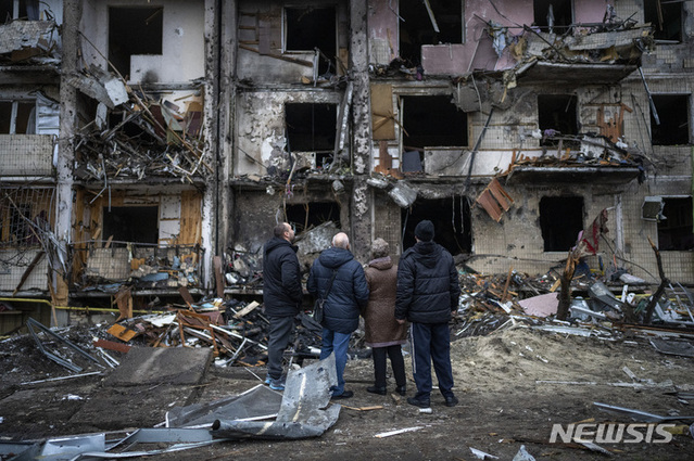 25일(현지시간) 우크라이나 키예프에서 주민들이 러시아의 로켓 공격으로 파손된 건물을 살펴보고 있다. ⓒ뉴시스