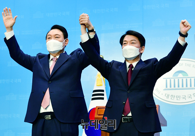 ▲ 윤석열 국민의힘 대선 후보와 안철수 국민의당 대선 후보가 3일 오전 국회 소통관에서 야권 단일화 합의 관련 공동 선언문 발표한 후 손을들어 인사하고 있다. ⓒ이종현 기자