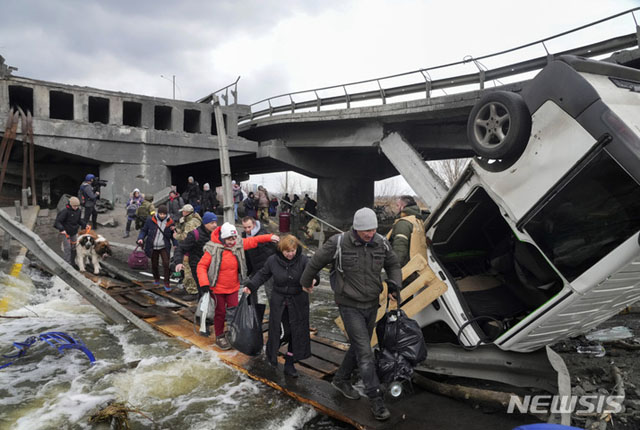 러시아군 포격으로 파괴된 다리 아래로 피난하는 우크라이나 시민들. ⓒ뉴시스 AP. 무단전재 및 재배포 금지.