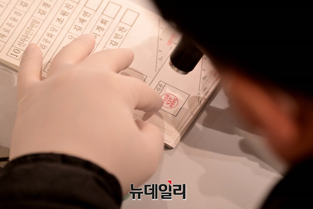 ▲ 제20대 대통령선거일인 9일 오전 선거관리위원회 관계자가 투표 용지에 투표관리관 도장을 찍고 있다. ⓒ강민석 기자