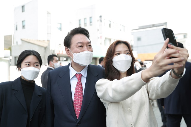 ▲ 윤석열 대통령 당선인이 16일 점심식사 후 서울 종로구 통의동 인근을 산책하며 시민들과 사진을 찍고 있다.ⓒ국민의힘 제공