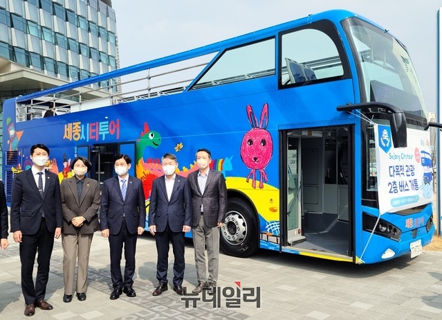 ▲ 이춘희 세종시장(왼쪽 세 번째)과 이태환 세종시의장(왼쪽 첫 번째)이 24일 시청 앞 광장에서 기관장들과 함께 세종시티투어 2층 버스 개통행사에 앞서 기념촬영을 하고 있다.ⓒ이길표 기자