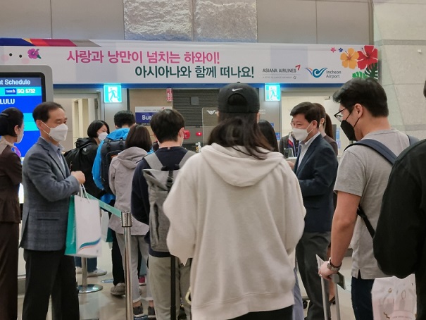 ▲ 지난 3일 인천공항 제1여객터미널 10번 탑승게이트에서 열린 '아시아나 항공 인천~하와이 노선 운항재개 행사'에서 인천국제공항공사 김범호 미래사업본부장(왼쪽에서 2번째)과 아시아나 오경수 여객본부장(오른쪽에서 2번째)이 아시아나항공 하와이(호놀룰루)행 항공편(OZ232편) 탑승 여객에게 기념품을 나눠주고 있다.ⓒ인천국제공항공사