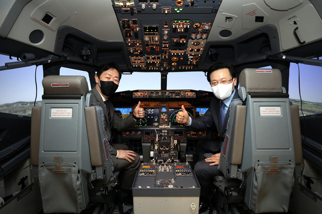 ▲ 윤형중(왼쪽) 한국공항공사 사장과 김이배 제주항공 대표이사가 시뮬레이터 안에서 기념촬영을 하고 있다. ⓒ제주항공
