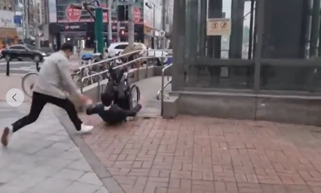 ▲ 6일 진성준 더불어민주당 의원이 휠체어를 타고 가양역 9번 출구 인근 경사로에 들어서는 도중 바퀴가 보도블록에 걸려 뒤로 넘어지고 있다. ⓒ진성준 의원 페이스북 캡처