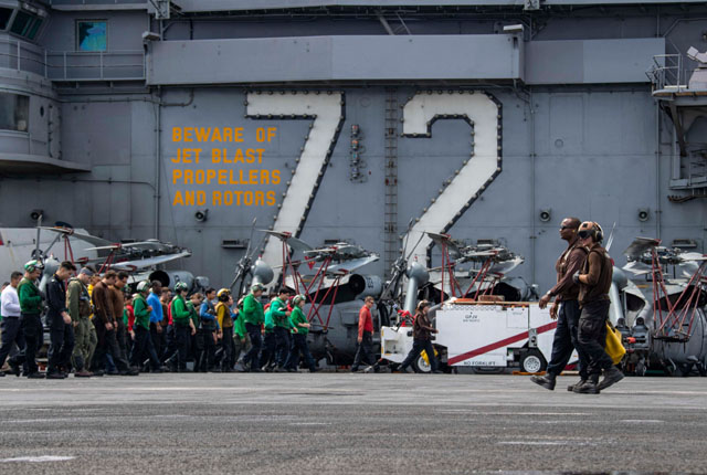 ▲ 일렬횡대로 걸으면서 비행갑판 이상을 점검하는 에이브러햄 링컨함 승조원들. ⓒ미해군 제공.