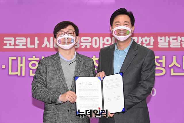 ▲ 오세훈(오른쪽) 서울시장과 김붕년 대한소아청소년정신의학회 이사장이 19일 '마스크 착용에 따른 영유아 뇌발달 실태조사' 관련된 업무협약을 맺고 기념촬영 하고 있다. ⓒ강민석 기자