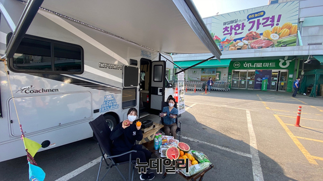 ▲ 18일 서울 서초구 농협 하나로마트 양재점에서 모델들이 캠핑 음식과 함께 캠핑카 대여서비스를 소개하고 있다. ⓒ농협유통