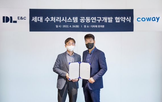 ▲ 지난 26일 서울 종로구 DL이앤씨 본사에서 최영락 DL이앤씨 주택기술개발 담당 임원(왼쪽)과 박준현 코웨이 법인사업실장이 세대 수처리시스템 공동연구개발 업무협약 후 기념 촬영을 하고 있다. ⓒ코웨이