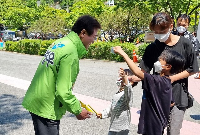 ▲ 김병우 충북도교육감 후보가 길거리에서 엄마와 함께 한 아이에게 눈을 마춰 이야기를 나누고 있다.ⓒ김병우 선거 캠프