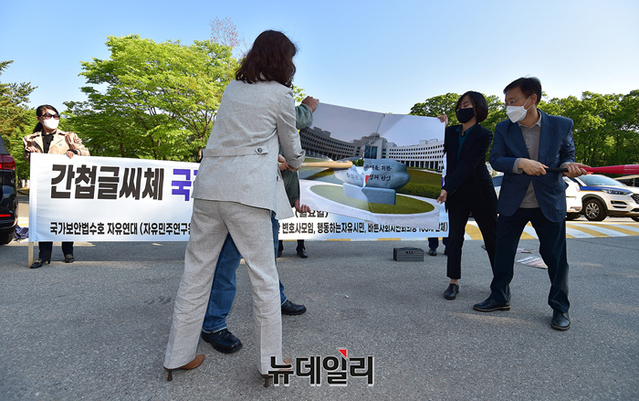 ▲ 국가보안법수호자유연대가 16일 오전 국정원 앞에서 연 기자회견에서 원훈석 사진을 부수는 퍼포먼스를 하고 있다. ⓒ정상윤 기자