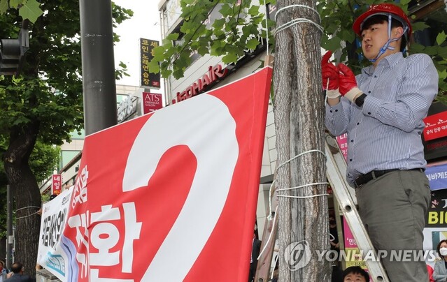 ▲ 국민의힘 이준석 대표가 20일 오전 광주 북구 전남대학교 후문 앞 거리에서 전날 고의 훼손된 광주 후보자들의 현수막을 다시 달고 있다. ⓒ연합뉴스