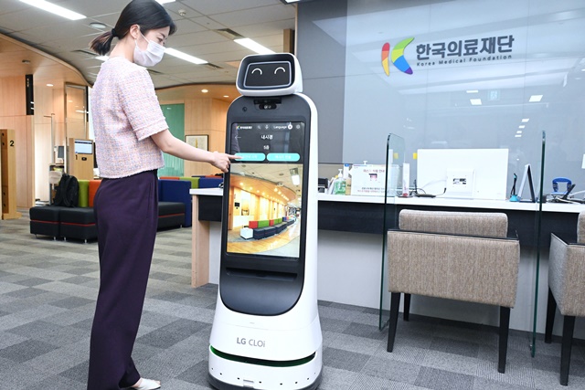 ▲ 한국의료재단 종합검진센터 직원이 LG 클로이 가이드봇을 활용해 건강검진 안내를 받는 모습을 시연하고 있다. ⓒLG전자