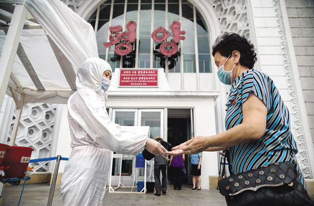 ▲ 평양역 앞에서 지나가는 시민에게 손소독제를 발라주는 방역요원. ⓒ연합뉴스. 무단전재 및 재배포 금지.