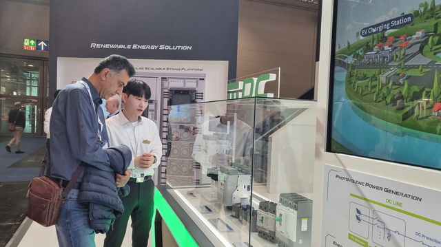 ▲ ‘하노버 메세 2022’에서 LS일렉트릭 관계자가 전시장을 찾은 해외 고객에게 차세대 직류(DC) 전용 전력기기를 소개하고 있다. ⓒLS일렉트릭