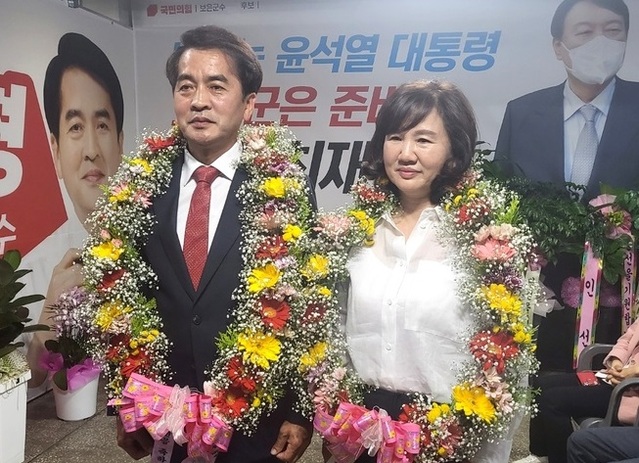 ▲ 최재형 국민의힘 보은군수 후보가 2일 새벽 선거 캠프에서 꽃다발을 목에 걸고 부인과 함께 즐거워하고 있다. ⓒ최재형 보은군수 후보 선거 캠프