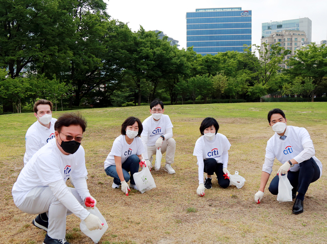 ▲ 유명순 한국씨티은행장(오른쪽에서 두번째)이 지난 2일 직원들과 함께 서울 경희궁에서 환경정화활동을 하고 있다. ⓒ한국씨티은행