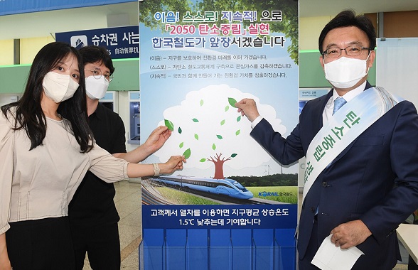 ▲ 나희승 코레일 사장(오른쪽)이 고객과 함께 일회용 컵 회수대에서 '나뭇잎 스티커'를 붙이고 있다.ⓒ코레일