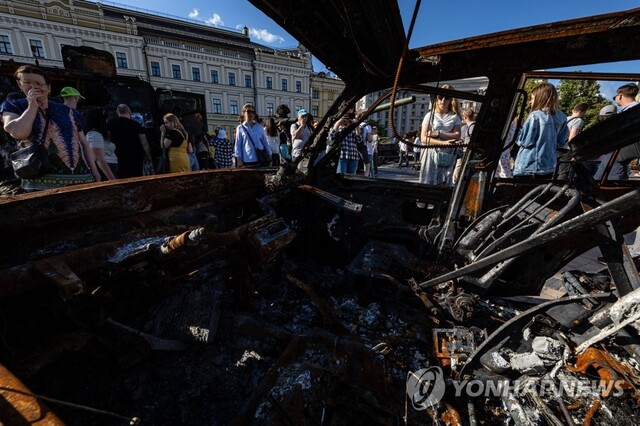 ▲ 18일 오후(현지시간) 우크라이나 키이우 중심인 성 미하일 황금 돔 수도원 앞에서 열린 러시아 침공군 파괴 무기 전시회를 찾은 시민들이 러시아군 공격으로 타버린 피난민의 승용차를 살펴보고 있다. ⓒ연합뉴스