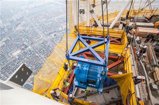 ▲ 롯데월드타워 최상부에 오티스 엘리베이터의 특수 권상기가 설치되고 있다. ⓒ롯데건설