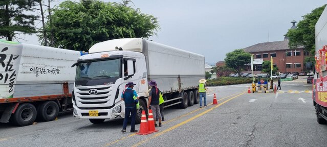 ▲ 화물연대 소속 차주들이 공장을 오가는 화물차의 번호판을 촬영하고 적재량을 살피고 있다.