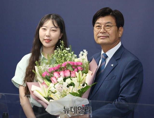 ▲ 이춘희 세종시장이 30일 오전 세종시청 정음실에서 기자회견을 마친 뒤 공보실 이원비 주무관에게 꽃다발을 받고 기념촬영을 하고 있다.ⓒ이길표 기자