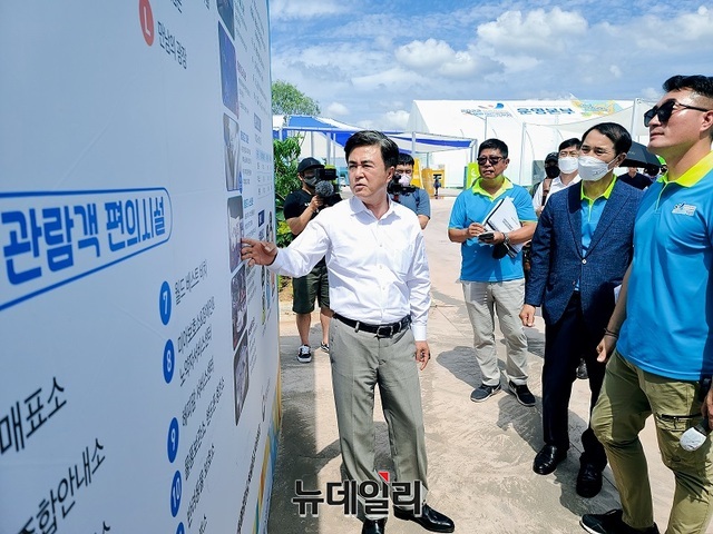 ▲ 김태흠 충남도지사가 6일 보령해양머드박람회장 입구에서 박람회 홍보물을 살펴본 뒤 조한영 사무총장과 김기정 총감독에게 보완을 지시하고 있다.ⓒ김정원 기자