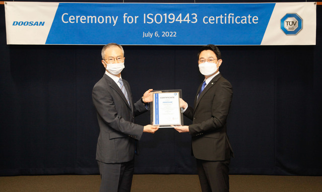 ▲ 강홍규 두산에너빌리티 원자력BG 상무와 서정욱 TUV SUD Korea 대표이사가 분당두산타워에서 열린 ISO 19443 인증서 수여식에서 기념촬영을 하고 있다. ⓒ두산에너빌리티