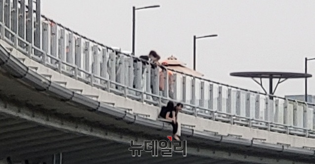 ▲ 8일 오전 5시 30분쯤 세종시 보람동 금강보행교 난간에 매달린 채 여중생 2명이 투신 소동을 벌이고 있다.ⓒ이길표 기자