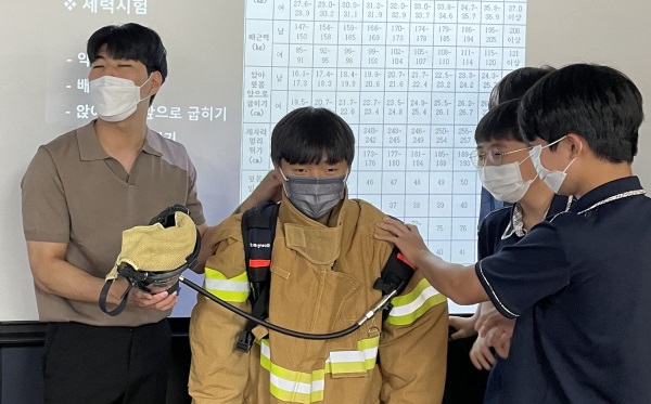 ▲ 대전버드내중학교에서 목원대 소방안전학과 대학생 멘토(왼쪽)가 중학생들의 소방안전장비 체험을 돕고 있다.ⓒ목원대
