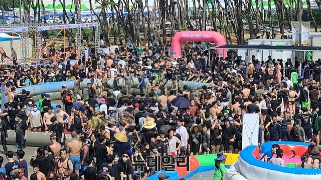 ▲ 2022 보령해양머드박람회가 16일 개막된 가운데 머드체험장에 외국인과 관광객들이 꽉 들어차 있다.ⓒ김정원 기자