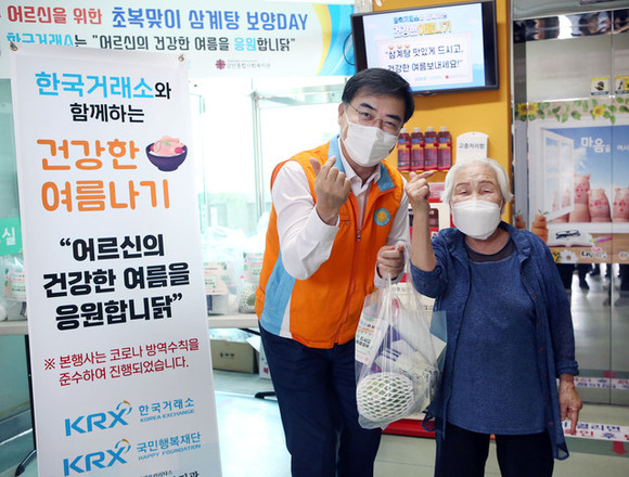 ▲ 한국거래소 손병두 이사장(왼쪽)이 20일 초복맞이 부산 남구 취약계층 지원 배식 봉사에서 간식을 전달하고 있다. ⓒ한국거래소