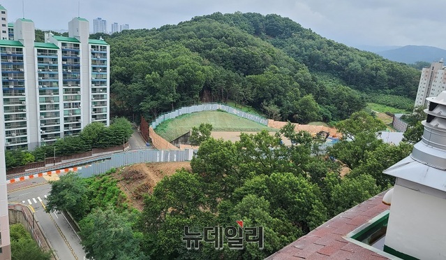 ▲ CMP도시개발㈜이 충남 천안시 동남구 일봉산을 깎아 아파트를 짓기 위해 벌목을 한 뒤 터파기 공사를 하고 있다. 이 아파트 공사현장과 도로 하나를 사이에 두고 아파트와 학교가 위치하고 있어 집중호우로 인해 토사가 연일 유출되고 있다.ⓒ김정원 기자