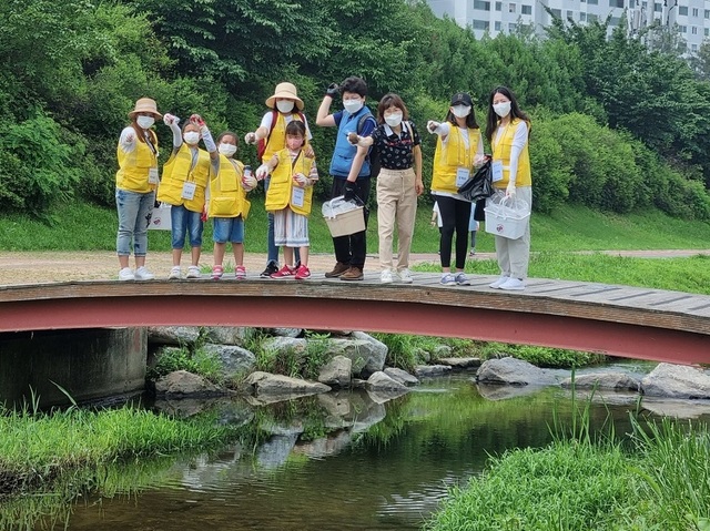 ▲ 천안시다문화가족지원센터는 지난 23일 ON가족봉사단과 포스코모빌리티솔루션 임직원 등 50여 명이 천안천 환경개선을 위한 ‘EM흙공 던지기’ 행사를 가졌다.ⓒ천안시