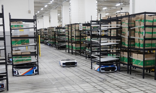 ▲ 군포 풀필먼트센터의 AGV(Automated Guided Vehicle·고정노선 운송로봇)가 박스를 이송하는 모습. ⓒCJ대한통운