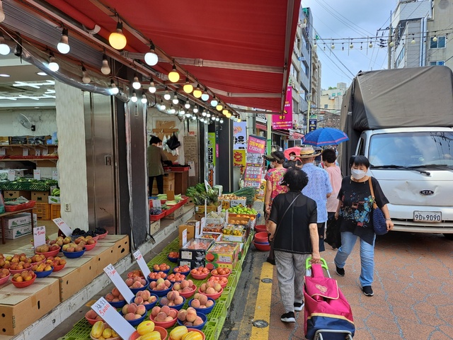▲ 4일 오전 10시 동작구에 위치한 성대시장에서 장을 보는 시민들이 한 과일 가게 앞을 지나가고 있다. ⓒ서영준 기자