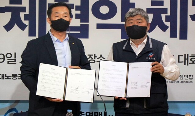 ▲ 김종철(왼쪽) CJ대한통운택배대리점연합회장과 김동명 한국노총전국연대노조 위원장이 협약 후 기념촬영을 하고 있다. ⓒCJ대한통운택배대리점연합