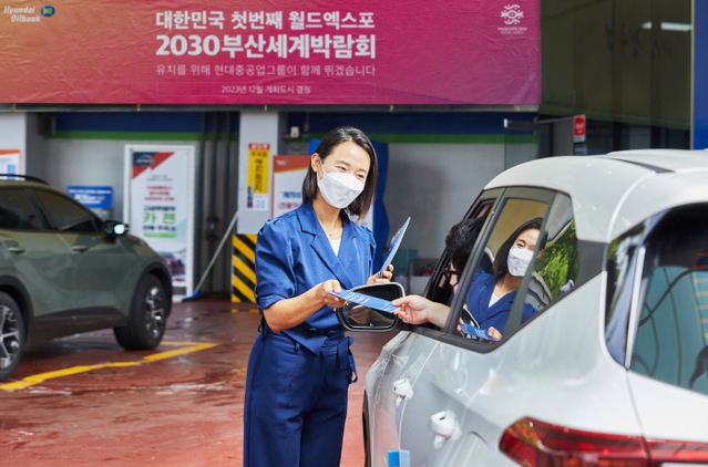 현대오일뱅크 직원이 직영주유소를 방문한 고객에게 2030 부산엑스포 유치 홍보 리플렛을 제공하고 있다. ⓒ현대오일뱅크 제공