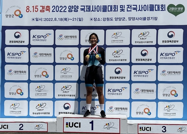 ▲ 음성고 자전거부 김도경 선수가 지난 18일부터 21일까지 강원도 양양군에서 열린 ‘8‧15 경축 2022 양양국제사이클대회·전국사이클대회’에서 금메달 2개를 획득했다. 김 선수가 시상대에서 금메달을 목에 걸고 즐거워하고 있다.ⓒ충북도교육청