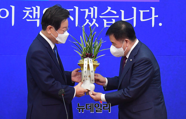 ▲ 이재명 더불어민주당 신임 대표가 30일 오전 국회에서 이진복 대통령실 정무수석으로부터 윤석열 대통령의 축하난을 전달받고 있다.ⓒ이종현 기자