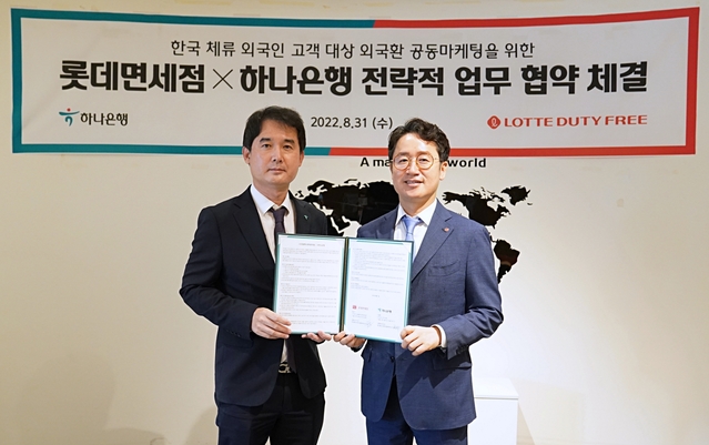 ▲ 31일 오전 서울 중구 하나은행 본사에서 김주남 롯데면세점 한국사업본부장(사진 우측)과 김익현 하나은행 외환사업본부장(사진 좌측)이 기념사진을 촬영하고 있는 모습.ⓒ호텔롯데