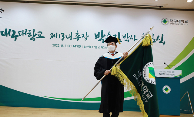 ▲ 박순진 총장이 취임식에서 교기를 전달받고 있다.ⓒ대구대