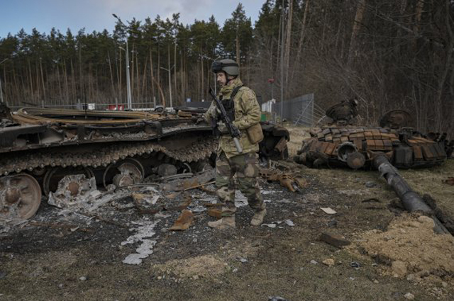 ▲ 우크라이나 병사가 파괴된 러시아 탱크 옆을 지나고 있다. ⓒ뉴시스 AP. 무단전재 및 재배포 금지.