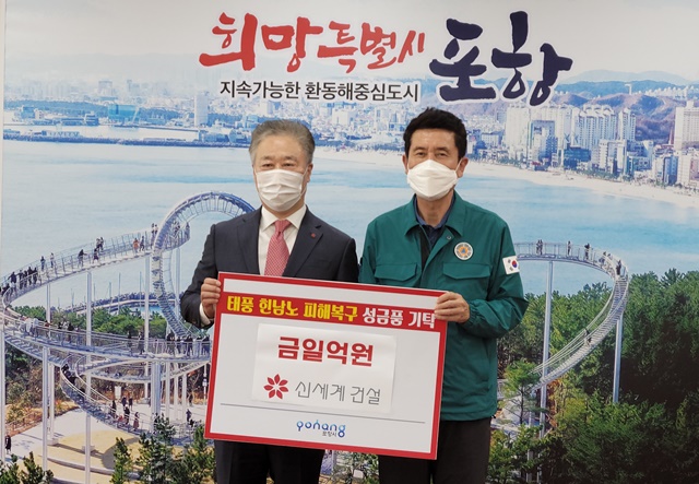 ▲ 정두영 신세계건설 건설 부문 영업본부장(좌)과 이강덕 포항시장이 전달식에서 기념촬영을 하고 있다. ⓒ신세계건설