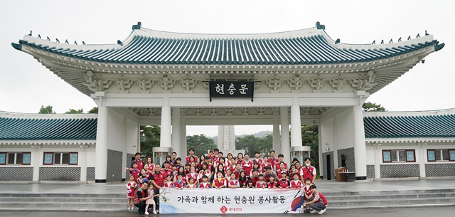 ▲ 롯데건설 임직원과 가족들이 현충문 앞에서 봉사활동 기념촬영을 하고 있다. ⓒ롯데건설