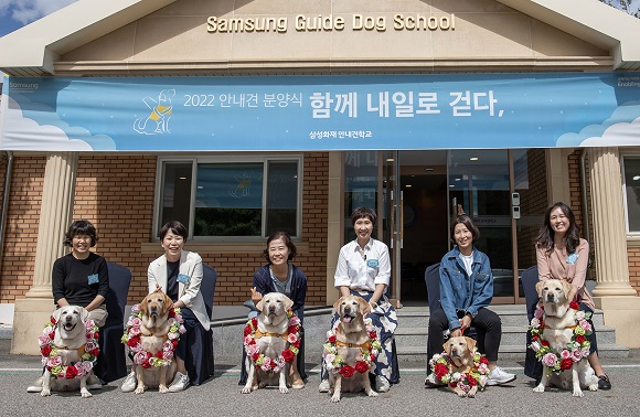 ▲ 20일 용인 삼성화재안내견학교에서 6년에서 8년간의 안내견 생활을 마치고 반려견으로 새롭게 삶을 시작하는 은퇴견 6마리와 입양가족이 기념 촬영을 하고 있다.ⓒ삼성전자