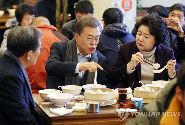 ▲ 문재인 전 대통령과 부인 김정숙 여사가 2017년 12월14일 오전 중국 베이징 조어대 인근 한 현지 식당에서 중국인들이 즐겨 먹는 아침 메뉴인 만두(샤오롱바오), 만둣국(훈둔), 꽈배기(요우티아오), 두유(도우지앙)을 주문해 식사를 하고 있다. 유탸오는 밀가루를 막대 모양으로 빚어 기름에 튀긴 꽈배기 모양의 빵으로 겉은 바삭하고 속은 말랑한 식감이 특징이다. 중국식 두유인 더우장에 적셔서 먹는 중국 일반 시민의 대표적인 아침 식사다. 왼쪽은 노영민 당시 주중 한국대사.ⓒ연합뉴스